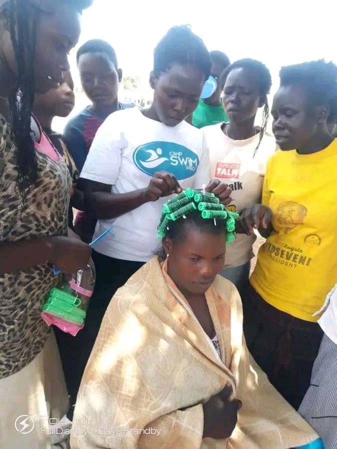 A young woman receiving hairdressing training with hair rollers as part of a vocational skills program
