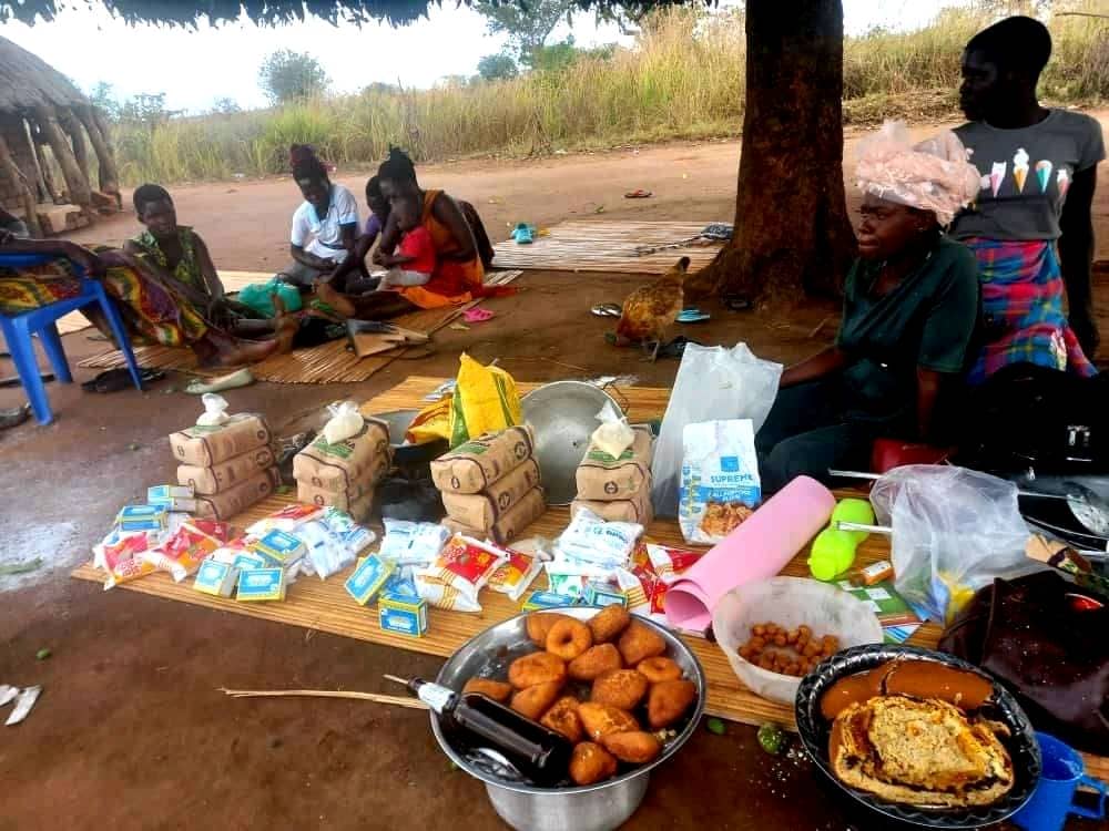 A VSLA group's savings and small goods laid out during a market day
